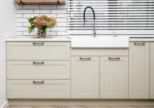 White kitchen furniture near the washbasin in white color in the style of milimalism.